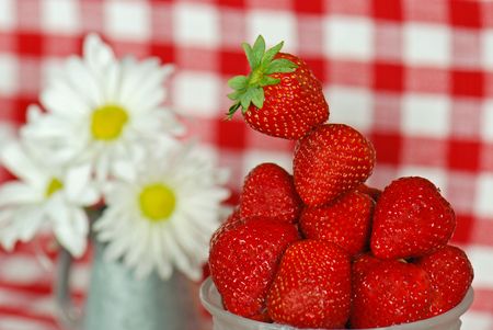 Ripe strawberries with a daisy bouquet.の写真素材