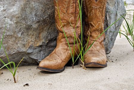 Cowboy boots by granite boulder.の写真素材