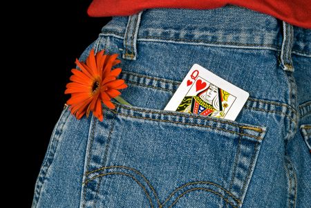 Queen of hearts card in blue jean pocket with daisy.の写真素材