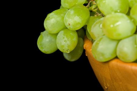 Wet green grapes in wooden bowl.の写真素材