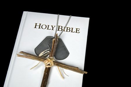 Military dog tags with cross on white Bible.