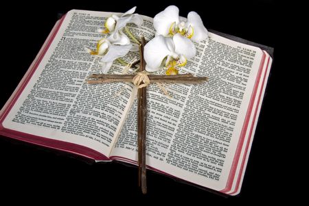 Cross and orchid blooms on open Holy Bible.の写真素材
