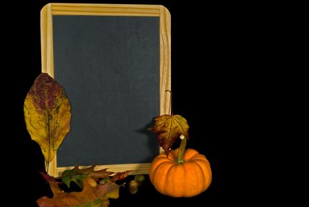 Autumn leaves and gourd with blank chalkboard.