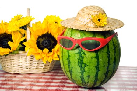 Sunglasses on a watermelon with sunflower bouquet.の写真素材