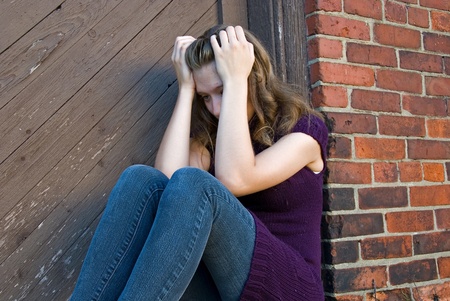 lonely teenage girl in old doorwayの写真素材