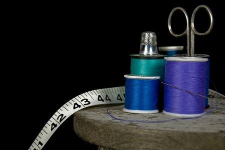 thimble on thread spools with scissor and tapeの写真素材
