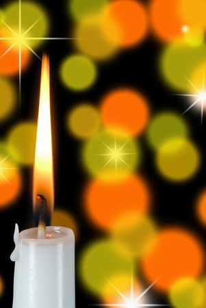 white candle burning on bokeh backgroundの写真素材
