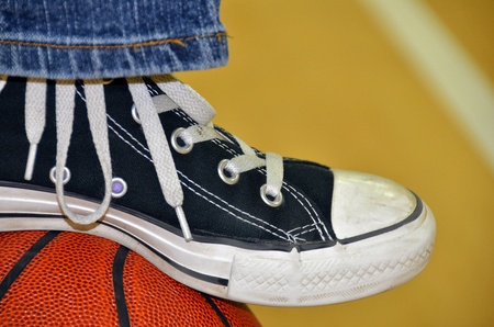 Sneaker resting on a basketball.