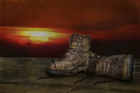 old work boots with sunset backgroundの写真素材