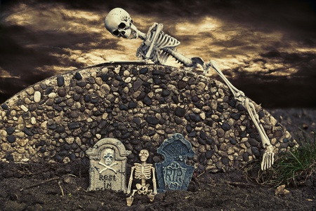 skeleton climbing over cemetery wallの写真素材