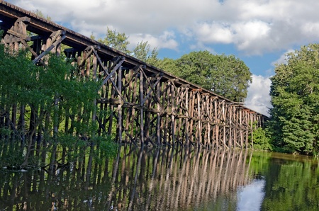 old wooden train trestle over a riverの写真素材