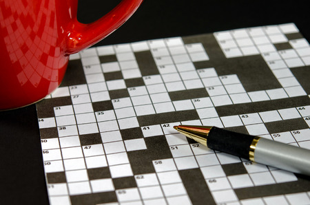 crossword puzzle with red mug and ink penの写真素材