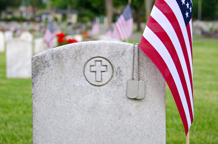 dog taqs on veteran s tombstone with flagの素材 [FY31030115478]