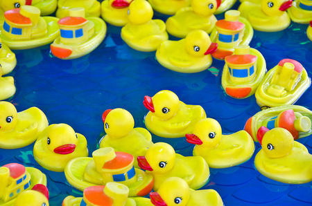 yellow rubber duck and toy boats in poolの写真素材
