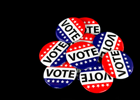 pile of patriotic voting pins on black