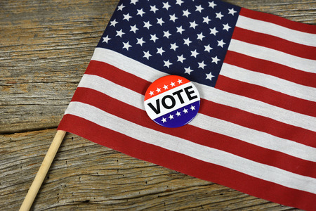 Vote pin on American flag with rustic wood backgroundの写真素材