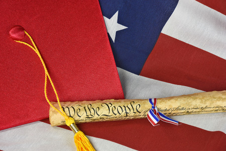 graduation cap and gold tassel on flag with old US constitutionの写真素材