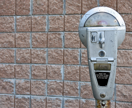 retro parking meter with brick wall backgroundの写真素材