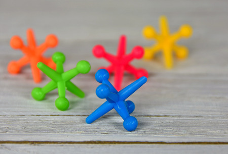 close up of colorful toy jacks on woodの写真素材