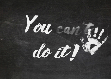 motivation message with hand print on black chalkboardの写真素材