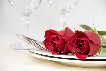 red roses and silverware on dinner plateの写真素材