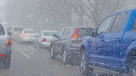 row of vehicles in traffic jam during snowstormの写真素材
