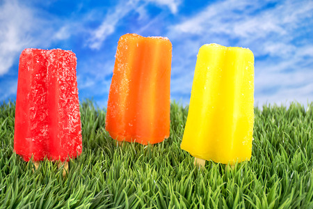 ice cream on a stick in grass with sky backgroundの写真素材