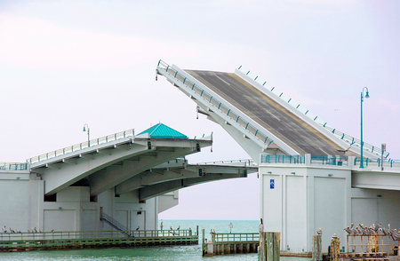 half opened Florida drawbridge with row of pelicansの写真素材