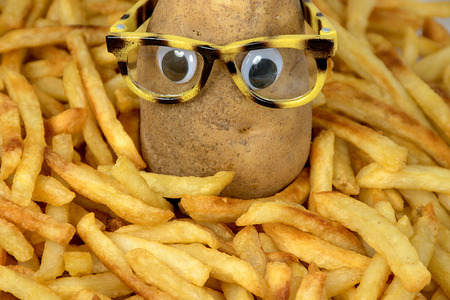 potato with eyeglasses in pile of golden french friesの写真素材