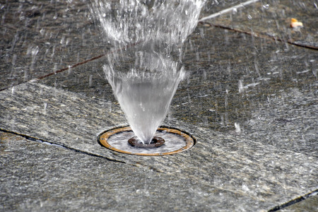 close up of splash pad fountain with water spray on city streetの写真素材
