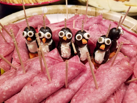 black olive penguins and ham on appetizer party plateの写真素材