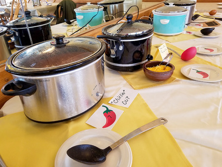 row of crock pots in chili cook off competition in restaurant