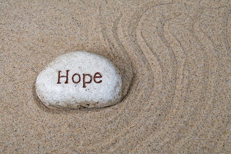 hope text engraved on a rock in beach sandの写真素材