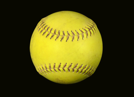 closeup of neon yellow softball isolated on blackの写真素材