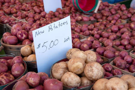 new potatoes with sign in produce bushel baskets at the farmer marketの写真素材
