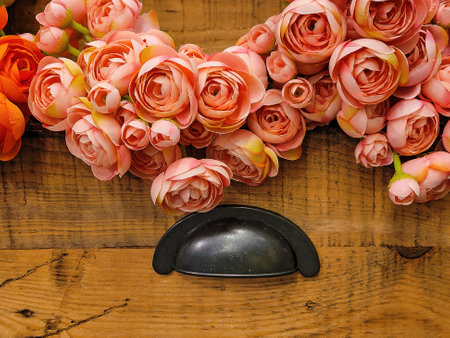 Orange roses in old vintage wooden drawer with black handle