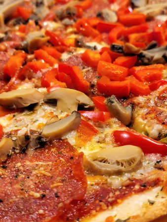 Close up of pepperoni and mushroom with red peppers on a pizzaの写真素材