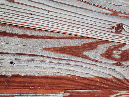 Close up of reddish-brown faded paint on weathered wood