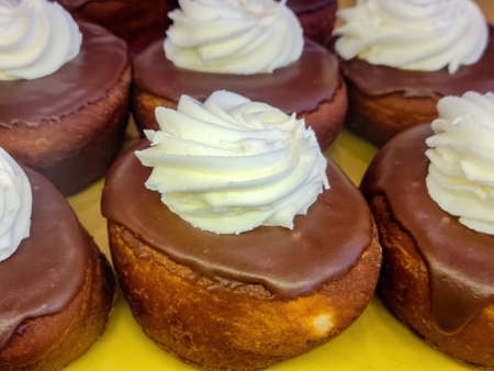 Bakery donuts with chocolate icing and white cream dollopの写真素材