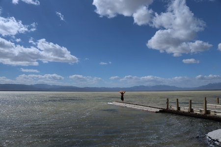 a woman stand on lake wooden platform