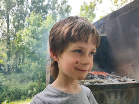 Happy face of a child on a picnic and baking food in the backgroundの写真素材