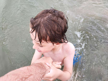 Father and son playing in the water in the river. Summer vacation.の写真素材