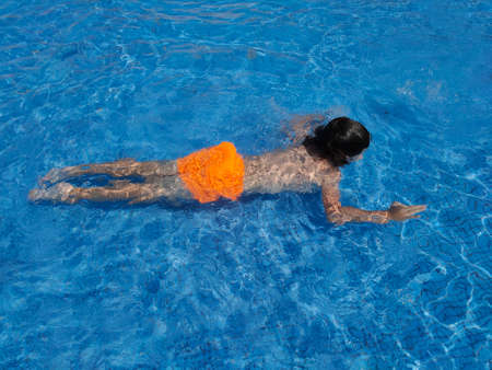 boy swims in the summer poolの写真素材