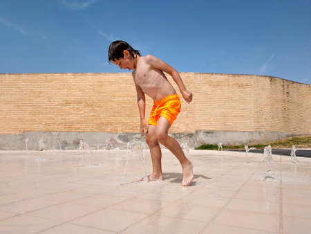 child playing with water from a fountain in the poolの写真素材
