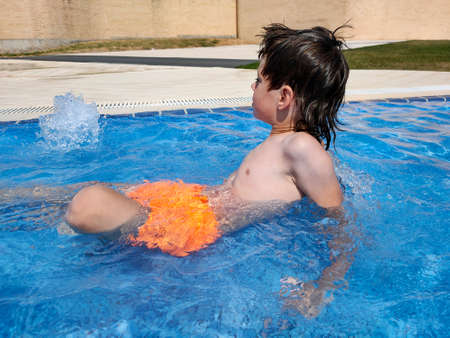 the child is sitting in the summer poolの写真素材