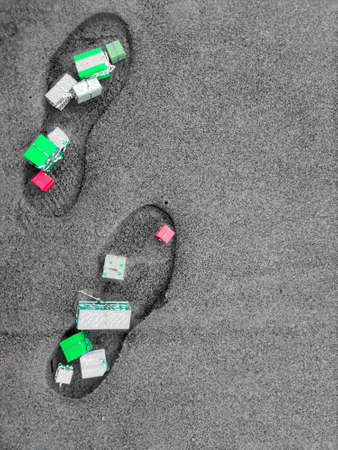 footprints of a man in the sand strewn with gifts. background for text. Congratulationsの写真素材