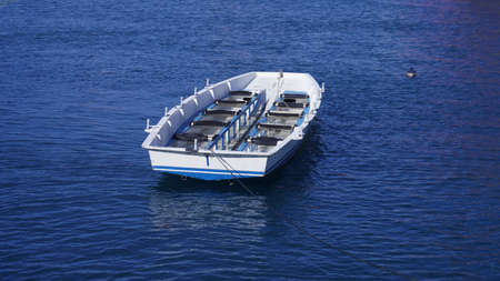 empty multi-seat boat sways on the waves, photo pictureの写真素材
