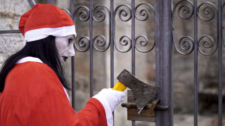 a man dressed as Santa Claus breaks the lock on the gate of the estateの写真素材