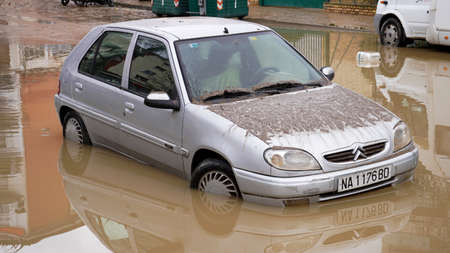 a car drowned covered in mud stands on a city street in the city of Pamplona, ââSpain on December 12, 2021のeditorial素材