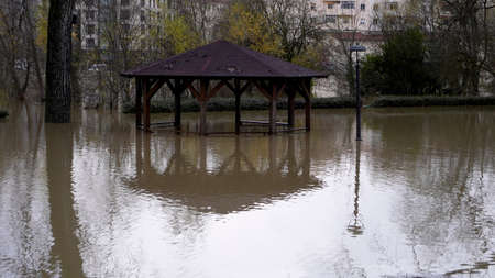 a wooden gazebo flooded in the water. reflection of the gazebo in the water. floodの写真素材